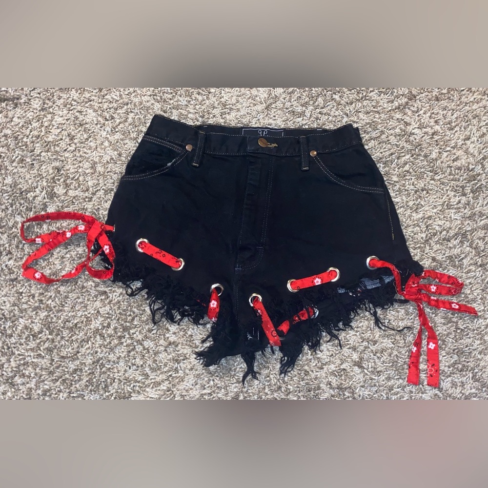 Black wrangler shorts with red bandana ribbon going though the bottom